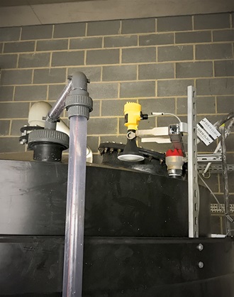 Een VEGAPULS 64-radarsensor, op een arm gemonteerd boven de opslagtank, meet het niveau van zoutzuur door het dak van de tank heen.